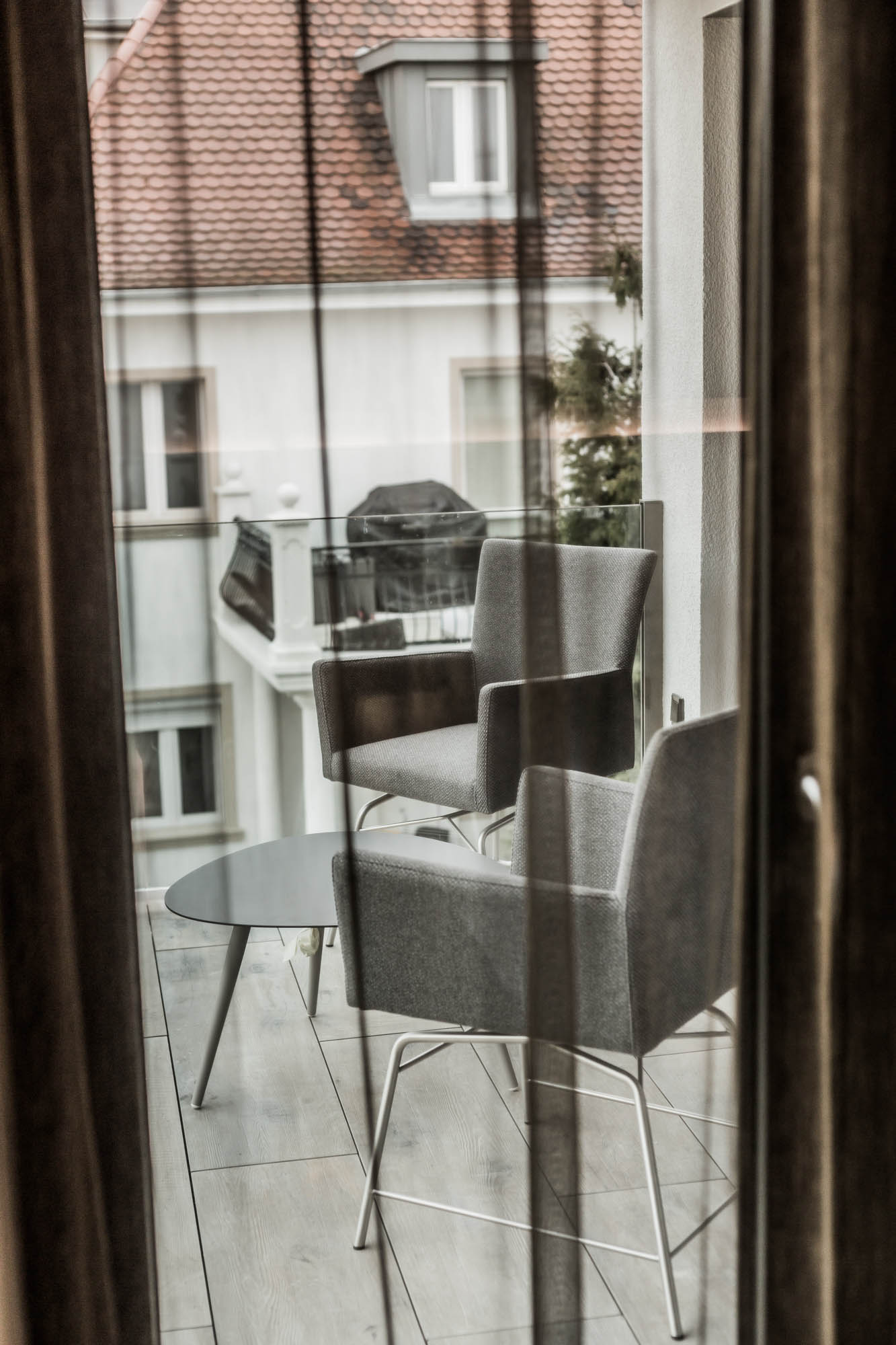 Blick auf die Loggia des Superior Apartments mit zwei grauen bequemen Sesseln und einem kleinen Tisch